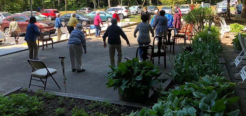 Senior citizens exercise outdoors.
