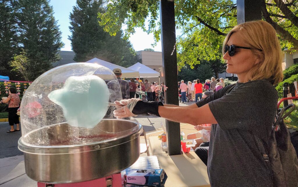 Volunteer giving cotton candy to residents.